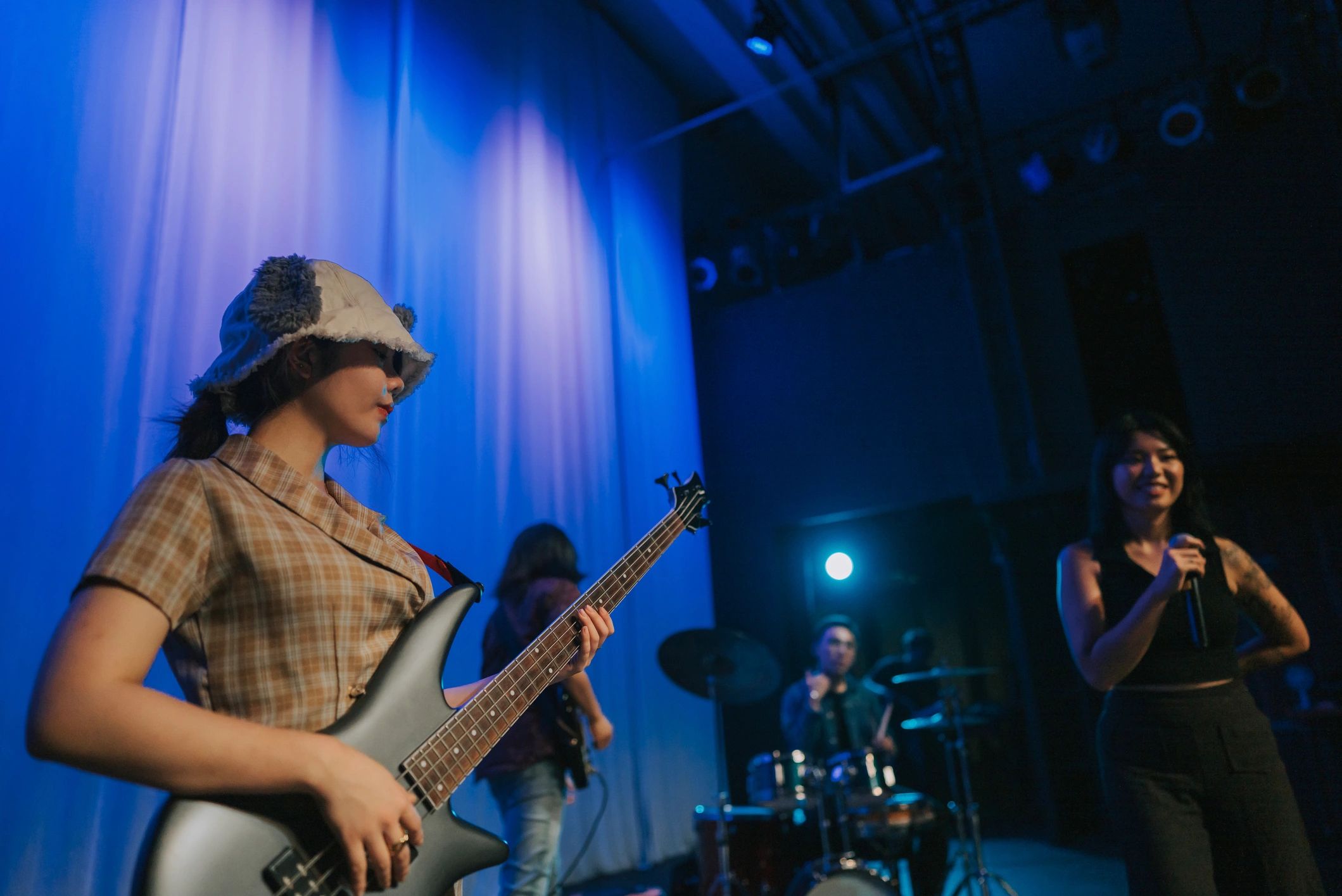 Female guitarist performing with a live band on stage