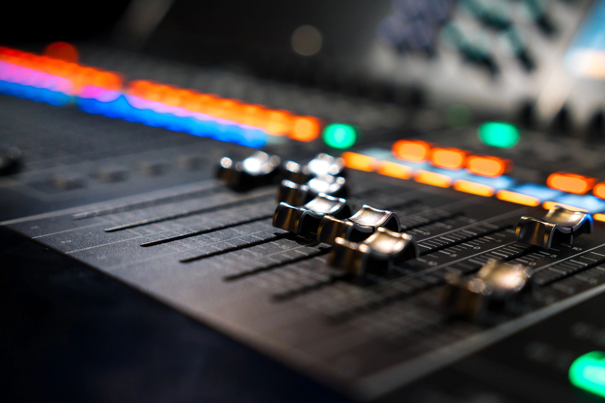 Close-up of a modern digital mixing console with faders