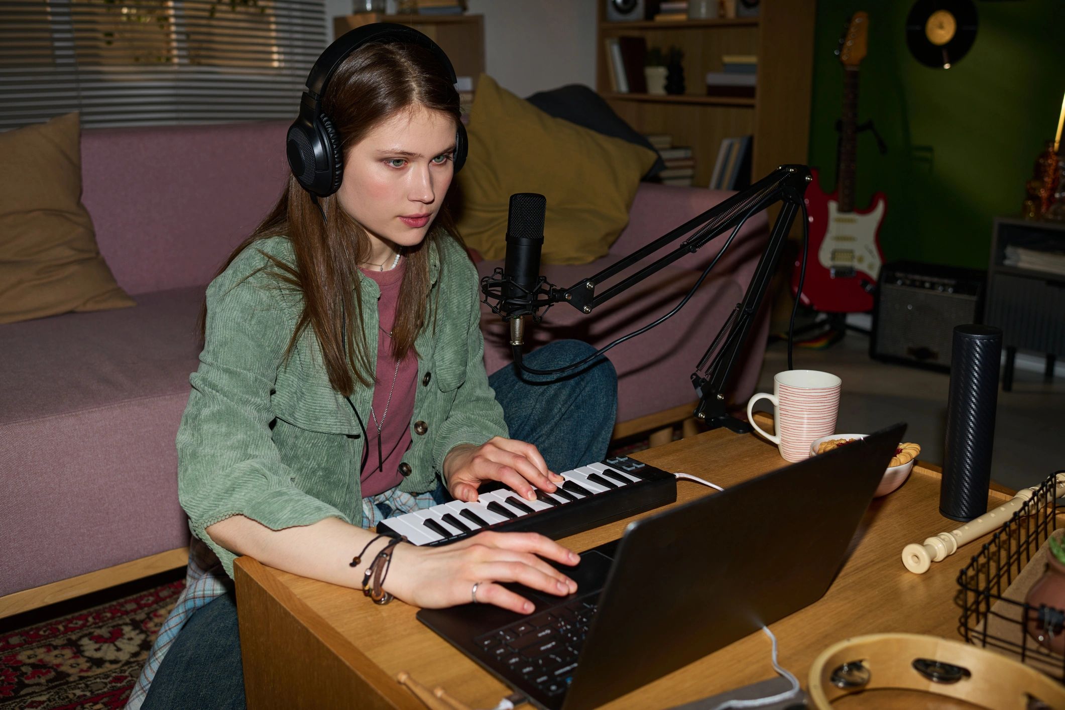 Music producer working in a studio with laptop and keyboard